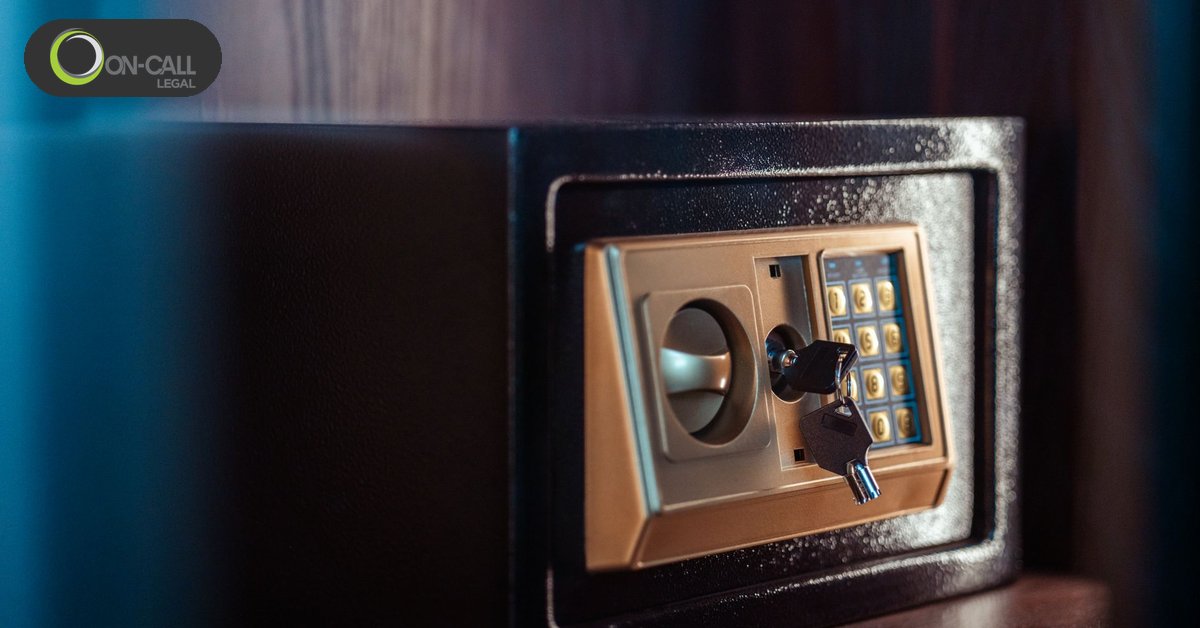 Close-up of a dark metal safe with a gold keypad and a key in the lock