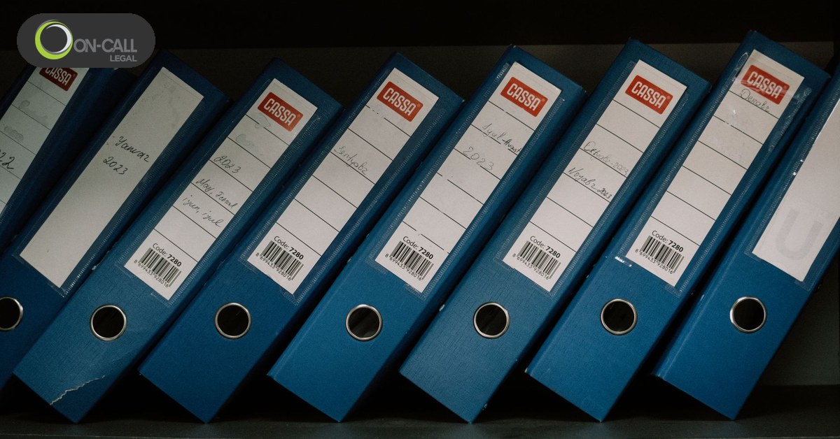 A row of labelled record binders on an office shelf